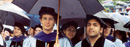 Doctor of Law graduates sit under umbrellas at the 2004 Commencement ceremony.
